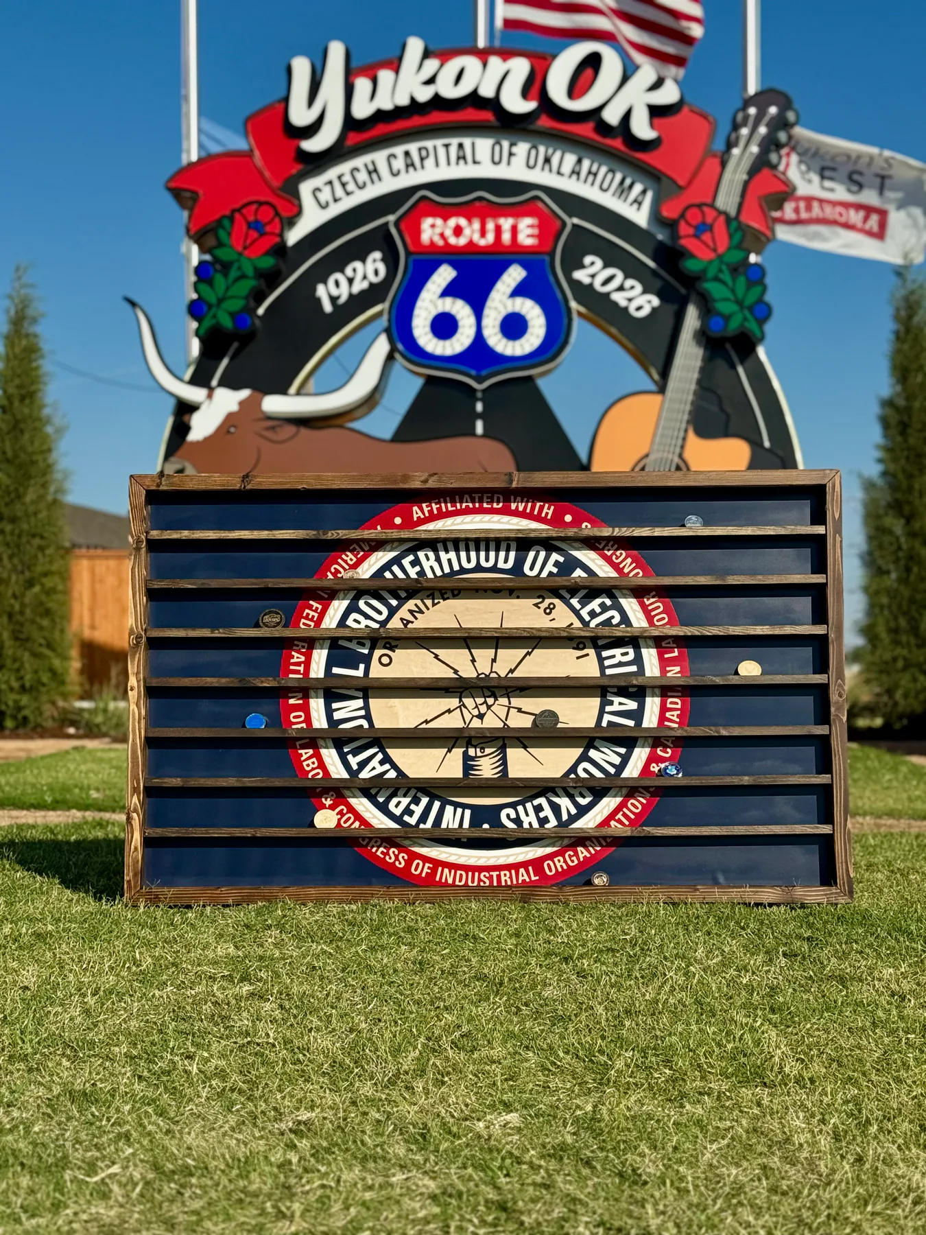 The blue IBEW challenge coin display photographed in front of the Yukon Route 66 landmark