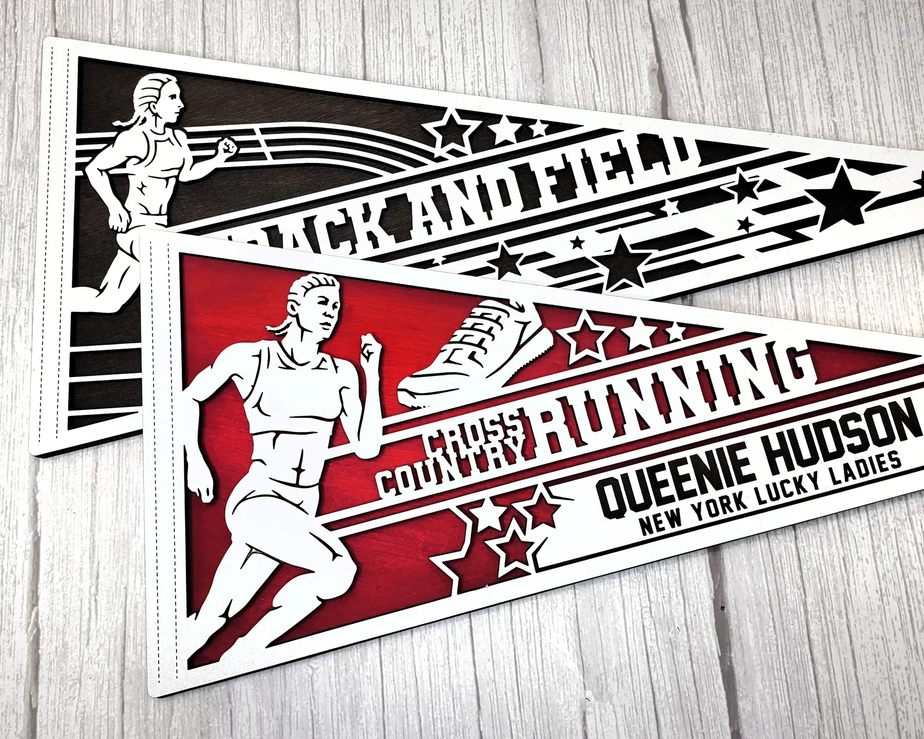 Supplier sample photo of layered cross country pennants with a personalized runner name